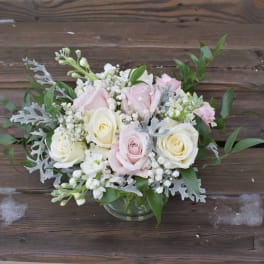 Pink and white roses arranged in a glass vase