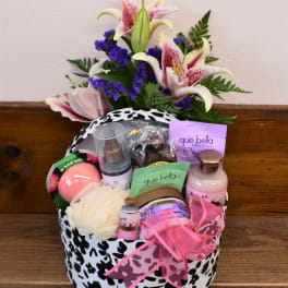 Gift basket with lilies and bath products in a black-and-white patterned box