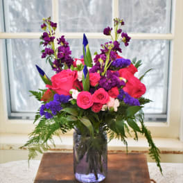 Pink and purple floral arrangement in a glass vase