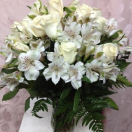 White roses and alstroemeria arranged in a glass vase