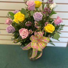 Bouquet of pink, yellow, and lavender roses with a plaid ribbon