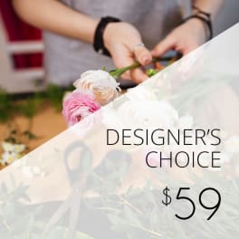 Hands arranging pink and white ranunculus flowers with "Designer’s Choice" text and $59 price.