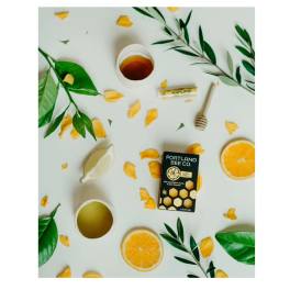 Honey soap bar with citrus slices and green leaves on a white background