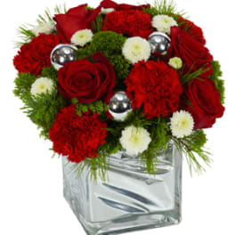 Red roses and carnations in a clear square vase with silver accents