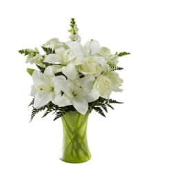 White lilies and roses in a green glass vase
