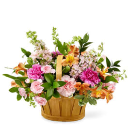 Mixed pink and orange flowers in a wooden basket