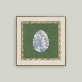 Framed decorative print with a blue-and-white egg motif on green fabric