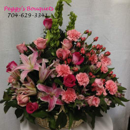 Pink mixed flower basket with roses, lilies, and carnations