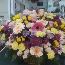 Large mixed bouquet of pastel and bright flowers in a basket