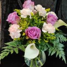 Pink and white bouquet with a white calla lily in a glass vase