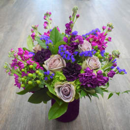 Purple and pink mixed bouquet in a dark vase
