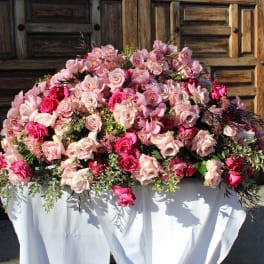 Large pink rose and orchid arrangement on a draped table
