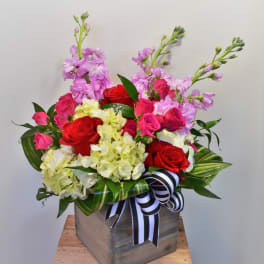 Pink and red roses with pale hydrangeas in a wooden box