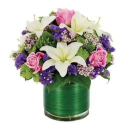 Bouquet of white lilies and pink roses in a green glass vase