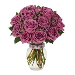 Pink rose bouquet in a clear glass vase with a beaded band