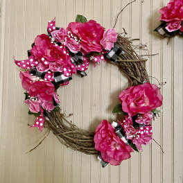 Pink floral wreath with ribbon on a twig base