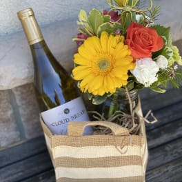 Flower gift bag with a wine bottle and a small mixed bouquet