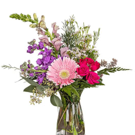 Mixed pink and purple flowers in a clear glass vase