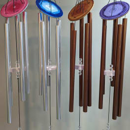 Four hanging wind chimes with colorful agate-style tops and metal tubes