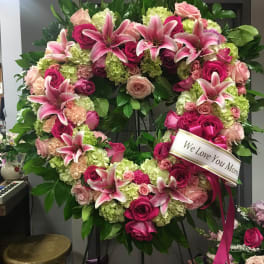Heart-shaped floral wreath with pink lilies, roses, and hydrangeas
