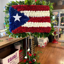 Large floral display shaped like the Puerto Rican flag on a stand