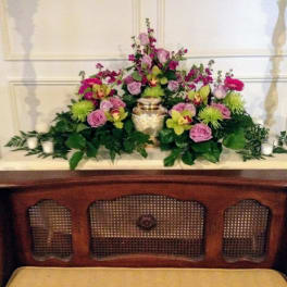 Pink and green floral arrangement with a gold urn centerpiece
