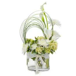 White flowers arranged in a clear glass vase with arched grass stems
