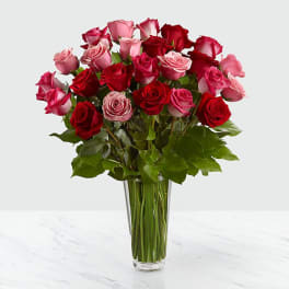 Bouquet of red and pink roses in a clear glass vase