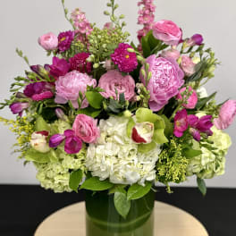 Pink and white mixed bouquet in a green glass vase