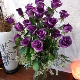 Bouquet of purple roses in a clear glass vase