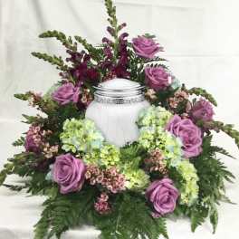 Lavender roses and hydrangeas arranged around a white urn