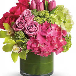 Pink roses and tulips with hydrangea in a green glass vase
