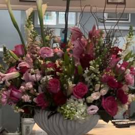 Large pink and white floral arrangement in a white vase