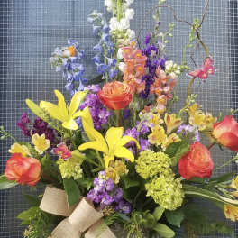 Colorful bouquet with yellow lilies, orange roses, and purple flowers