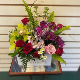 Mixed bouquet in a white box with roses, orchids, and purple butterflies