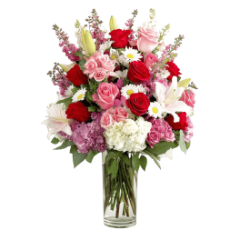 Mixed bouquet of roses, lilies, daisies, and hydrangeas in a clear glass vase