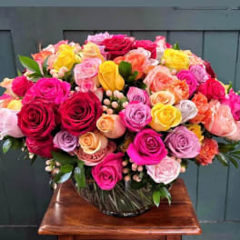 Large bouquet of multicolored roses in a glass vase