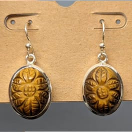 Pair of oval dangling earrings with carved amber-colored stones