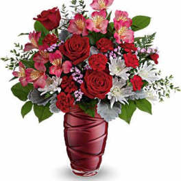 Red roses and pink alstroemeria in a burgundy vase