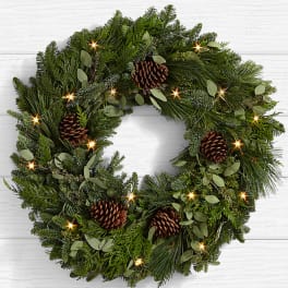 Evergreen wreath with pinecones on a white background