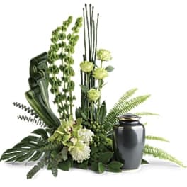 Green floral arrangement with a black urn