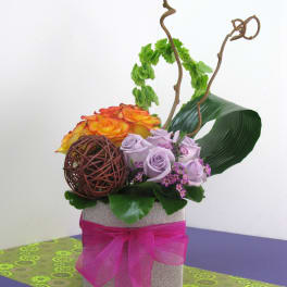 Lavender and orange roses in a square gift box with a pink ribbon