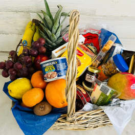 Wicker basket filled with fruit and packaged snacks