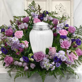 Purple and pink rose funeral wreath with a white urn centerpiece