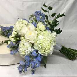 Bouquet of white hydrangeas and blue flowers with greenery