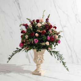 Mixed roses arranged in a cream urn vase