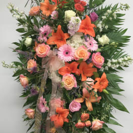Large standing spray of orange lilies, pink roses, and gerbera daisies