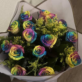 Bouquet of rainbow-colored roses wrapped in white paper