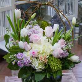 Pink and white tulips with roses in a glass vase