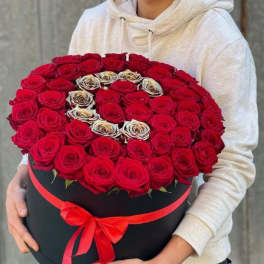 Large round box of red roses with a red ribbon bow